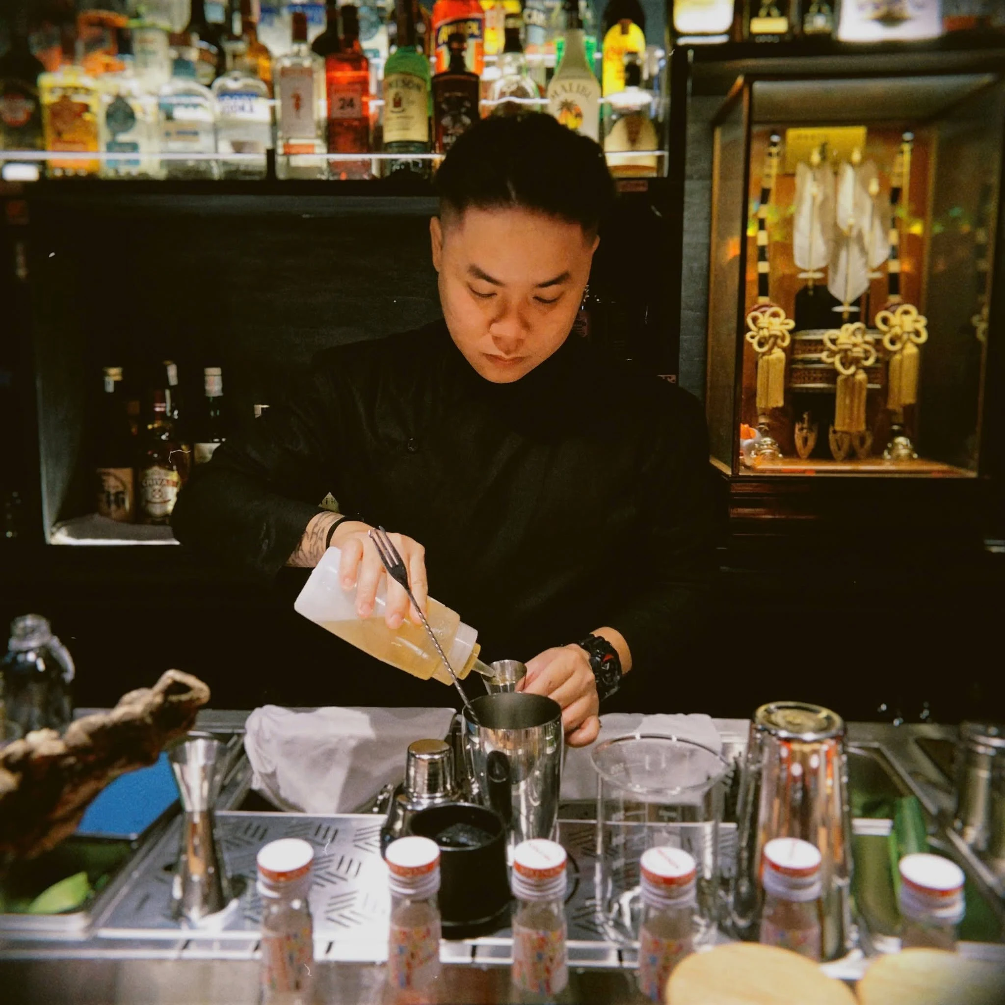 Bartender preparing a cocktail behind the bar